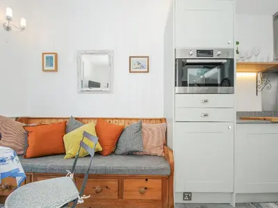 a living room with a couch with pillows on it at Zawn Nook in Falmouth