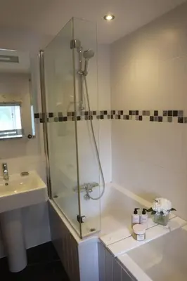 a bathroom with a shower and a sink at Cosy thatched Cottage sleeps 6 near Portscatho! in Porthscatho