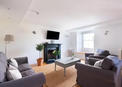 a living room with two couches and a fireplace at Georgian Apartment with Courtyard in Boscastle - Ideal for Couples and Families in Boscastle