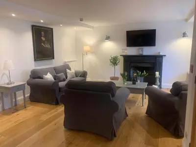 a living room with two couches and a fireplace at Georgian Apartment with Courtyard in Boscastle - Ideal for Couples and Families in Boscastle