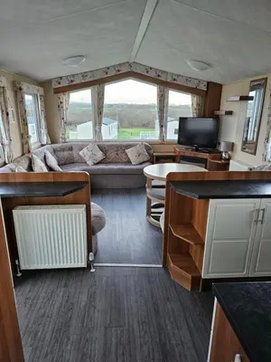 a living room with a couch and a tv in a bus at 113 Caravan at meadow lakes in St Austell