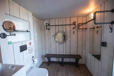 a bathroom with a toilet and a wooden wall at THE ANNEXE AT UPPER BEACH HOUSE in Portreath