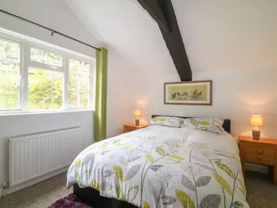 a bedroom with a bed and two windows at The Granary in Bodmin