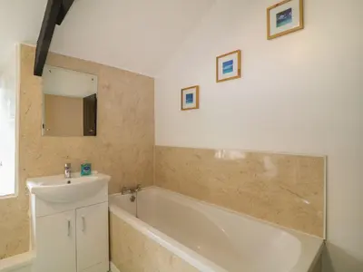 a bathroom with a bath tub and a sink at The Granary in Bodmin