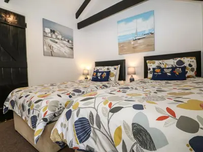 a bedroom with a bed with a comforter on it at The Granary in Bodmin