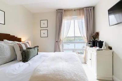 a bedroom with a white bed and a window at The King Of Prussia in Fowey