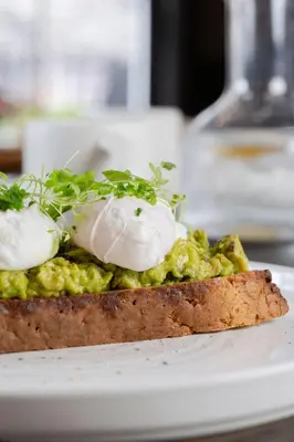 a piece of bread with poached eggs on top at The King Of Prussia in Fowey