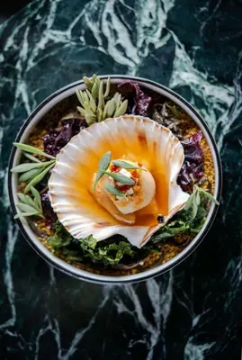 a bowl of food with a shell on a table at The King Of Prussia in Fowey