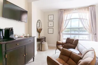 a bedroom with a couch and a chair and a television at The King Of Prussia in Fowey