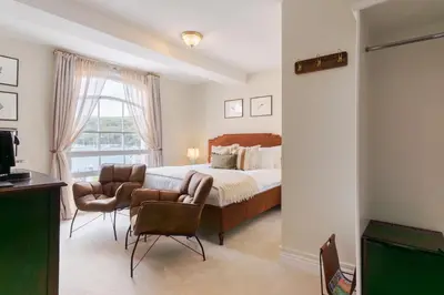 a bedroom with a bed and a couch and a window at The King Of Prussia in Fowey