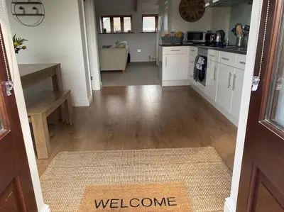 a hallway of a kitchen with a welcome mat on the floor at The Old Smelting Works in Truro