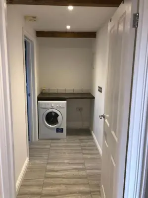 a hallway with a washing machine in a room at The Old Smelting Works in Truro