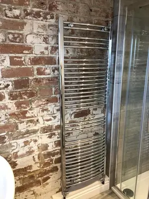 a shower in a bathroom with a brick wall at The Old Smelting Works in Truro