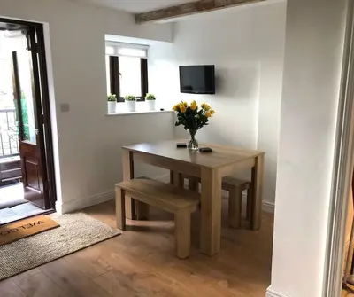 a room with a table with a vase of flowers on it at The Old Smelting Works in Truro