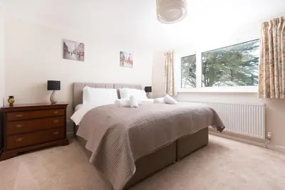 a bedroom with a bed and a window at Talland Croft in Crantock