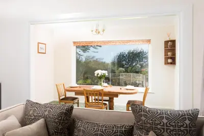 a living room with a couch and a table at Talland Croft in Crantock