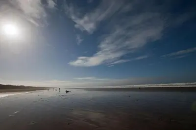 a group of people walking on the beach at Talland Croft in Crantock