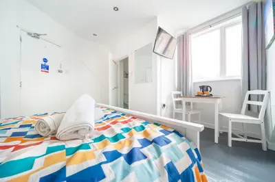a bedroom with a bed with towels on it at Tolcarne Guest House in Newquay