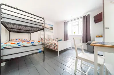 a bedroom with a bunk bed and a desk at Tolcarne Guest House in Newquay