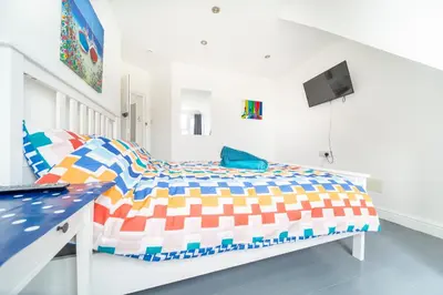 a bedroom with a bed and a tv in it at Tolcarne Guest House in Newquay