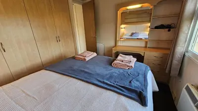 a small room with a bed with two towels at Penmor in Bude