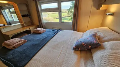 a bedroom with a large bed with a mirror at Penmor in Bude