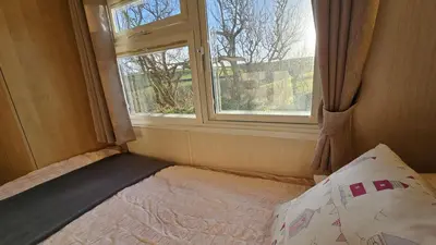a bed in a small room with a window at Penmor in Bude