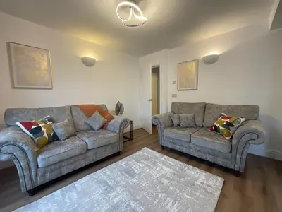 a living room with two couches and a rug at Gregory Flats No. 1, by HomeInspire in Looe