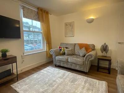 a living room with a couch and a window at Gregory Flats No. 1, by HomeInspire in Looe