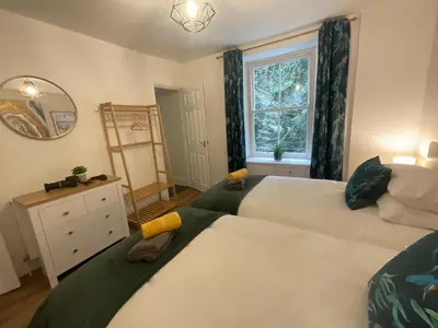 a bedroom with two beds and a window at Gregory Flats No. 1, by HomeInspire in Looe