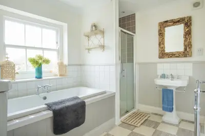 a bathroom with a tub and a sink at St Edwards Cottage, Tintagel in Tintagel