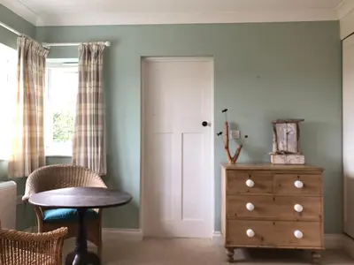 a room with a door and a table and a dresser at St Edwards Cottage, Tintagel in Tintagel