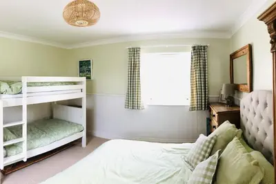 a bedroom with a white bunk bed and a window at St Edwards Cottage, Tintagel in Tintagel