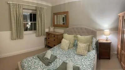 a bedroom with a bed and a window at St Edwards Cottage, Tintagel in Tintagel
