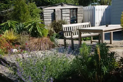 a bench and a table in a garden at St Edwards Cottage, Tintagel in Tintagel