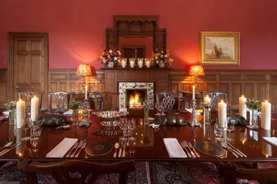 a dining room with a table with candles and a fireplace at Lostwithiel Manor in Braddock