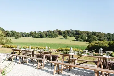 a group of wooden picnic tables in a field at Lostwithiel Manor in Braddock