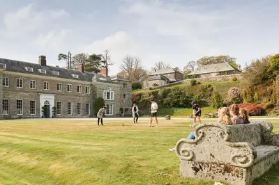a group of people playing a game in the yard of a castle at Lostwithiel Manor in Braddock