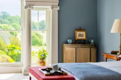 a bedroom with a bed and a large window at Lostwithiel Manor in Braddock