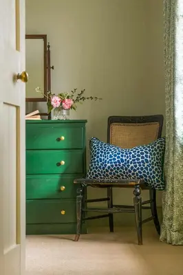 a bedroom with a dresser and a chair with a pillow at Lostwithiel Stable House in Braddock