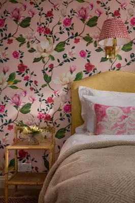 a bedroom with a bed with flowers on the wall at Lostwithiel House in Braddock