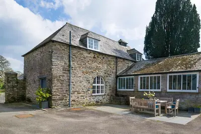 a stone house with a table and a bench at Lostwithiel House in Braddock
