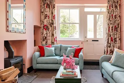 a living room with two couches and a fireplace at Lostwithiel Dairy House in Braddock
