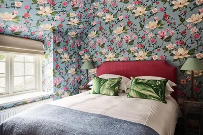 a bedroom with a bed with a floral wallpaper at Lostwithiel Dairy House in Braddock