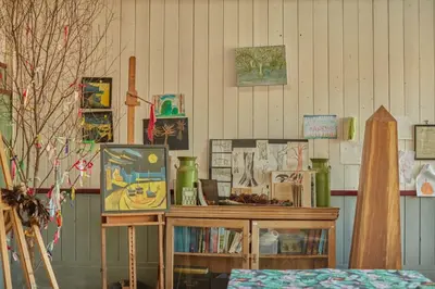 a room with a table with paintings on the wall at Lostwithiel Dairy House in Braddock