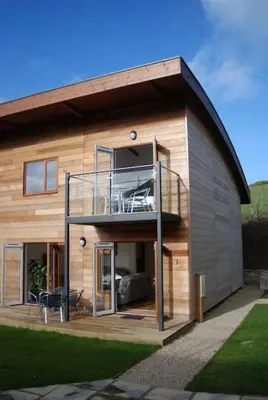 a small house with a balcony on the side of it at Valentyne Beach House in Porthtowan
