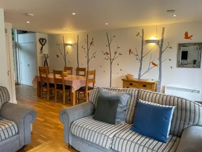 a living room with a couch and a dining room at Valentyne Beach House in Porthtowan