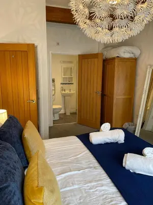 a bedroom with a large bed with towels on it at Valentyne Beach House in Porthtowan