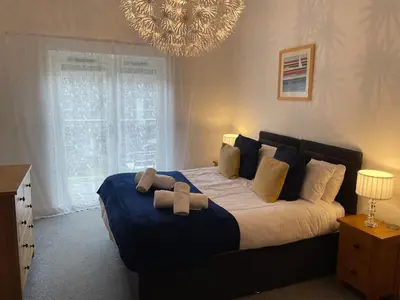 a bedroom with a large bed with two stuffed animals on it at Valentyne Beach House in Porthtowan