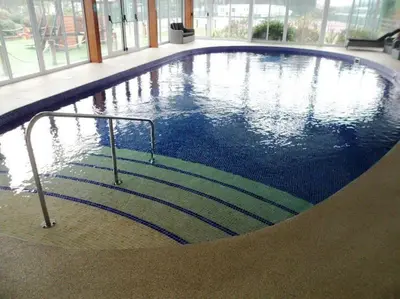 a swimming pool with stairs in a building at Delightful two bedroom caravan on Par Beach. in Par